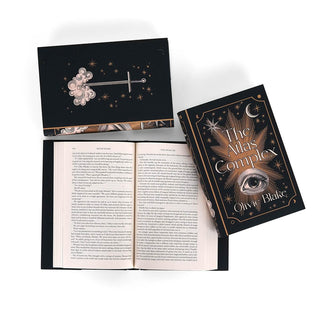 Detail shot of The Atlas series. Open book displays print size surrounded by books in series sitting with front and back cover facing up. Back cover features wood cut illustrated sword and cloud surrounded by cooper colored stars