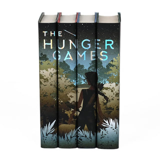 A girl with a bow standing in front of foliage. The Hunger Games limited edition collectible book set featuring custom dust jackets from Juniper Books.