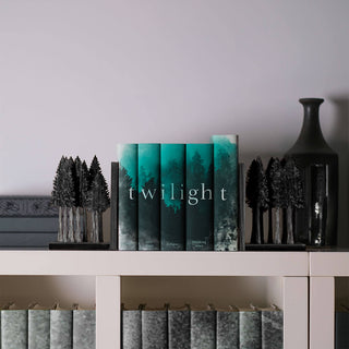 Twilight book set sitting on white bookshelf surrounded by grey books and two wooden forest bookends.