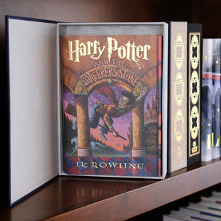 Harry Potter book jackets in an open Black Juniper Books Dust Jacket Storage Box  a wooden shelf.
