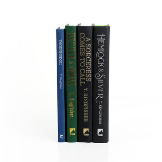 Unjacketed T. Kingfisher Books showing original spines beneath Juniper Books book covers.