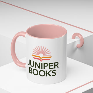 Juniper Books Logo Mug in pink. Outside of mug is white with Black Juniper Books logo. Interior and handle are light pink.