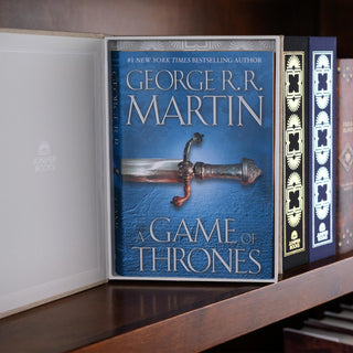 A Song of Ice and Fire book jackets in an open Neutral Juniper Books Dust Jacket Storage Box  a wooden shelf.