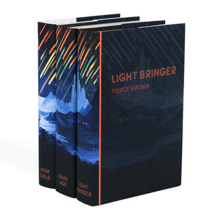 Angled view of three hardcover books from Pierce Brown's Red Rising series: Iron Gold, Dark Age, and Light Bringer. The dust jackets form a continuous illustration of Mercurian city, and a colorful iron rain. The title Light Bringer and author name Pierce Brown are prominently displayed on the front cover of the rightmost book.