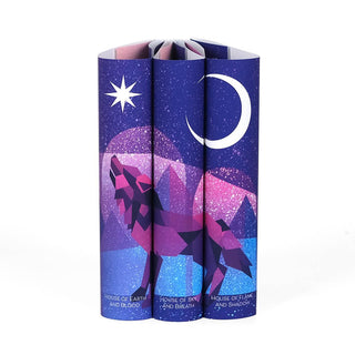 Dust jackets featuring pink and purple hues, a howling wolf set against mountains, and a starry sky. Star and crescent moon above wolf. Each dust jacket has book title centered at bottom of spine in white san serif font. 