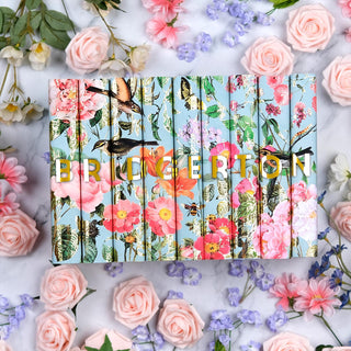 Limited Edition book covers for Bridgerton book set by Julia Quinn styled on a marble background scattered with flowers with covers by Juniper Books.