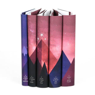 Dust jackets feature pink and purple mountains adorned with three stars span across book spines in the A Court of Thorns and Roses Book Set.