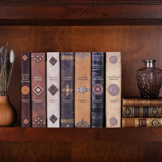 Special Edition book covers for Game of Thrones Armor book set by George R.R. Martin styled on a bookshelf with covers by Juniper Books.