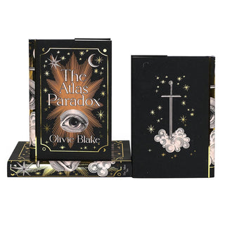 Dust jacket front covers feature woodcut eye illustration surrounded by gold foil stars and ornamental detailing. Covers feature book title and author name. Back cover features gold foil stars and woodcut illustrated style sword.