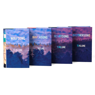 A set of four hardcover books arranged in a row, showing the front covers. Each cover features a landscape design with a forest silhouette at the bottom and a sky transitioning from blue to purple hues. The book titles are displayed in holographic foil along with the author's name, TJ Klune. The cohesive design connects the books with similar color tones and a serene, atmospheric theme.