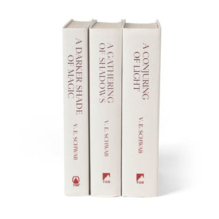 Unjacketed books for the Shades of Magic series by V.E. Schwab. Books are white with red text down the spines.