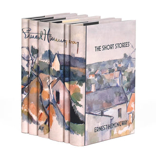Angle shot of the Ernest Hemingway set from Juniper Books. Covers feature book title and author and a portion of the painting "Rooftops" by Paul Cézanne.