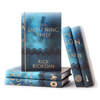 Percy Jackson book covers feature title and author typed in gold serif font against blue watercolor background and dark blue symbol silhouette centered on cover.