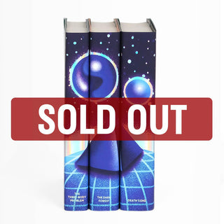 Limited Edition The Three-Body Problem dust jackets features blue and purple shiny orbs floating above a blue pyramid. Book title names typed across bottom of book spines in iridescent foil serif type. Spines accented with iridescent foil.
