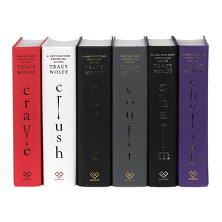Unjacketed books in the Crave series by Tracy Wolff. Book spines are red, white, black, grey, and purple.