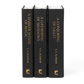 Unjacketed collector edition books for Shades of Magic series by V.E. Schwab. Book are black with gold type down the spines.
