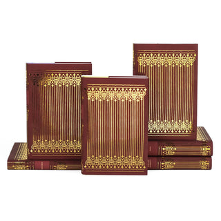 A stack of elegant Jane Austen hardcover books with deep red covers and intricate gold foil patterns. The books are displayed in an overlapping arrangement, showcasing the ornate gold foil designs on the covers and spines.