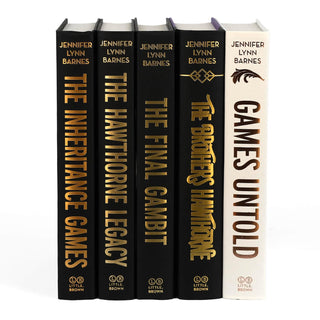 Unjacketed spines for The Inheritance Games Series by Jennifer Lynn Barnes. The spines for Games Untold is white, and the other four books are black. Spines display book title, author’s name, and publisher’s name in gold foil.
