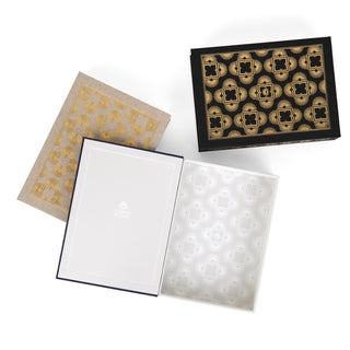 Three dust jacket boxes designed by Juniper Books, shown from above. Each box displays an intricate, symmetrical pattern. The beige box has gold patterns, the black box has gold patterns, and the navy blue box has silver patterns. The interiors of the boxes feature a lighter version of the pattern and the Juniper Books logo on the inside cover of the navy blue box.