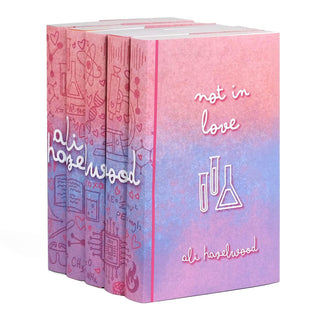 A set of five Ali Hazelwood novels in custom designed book jackets photographed from an angle on a white background. A continuous design is visible across the spines of all five books, with the name 'Ali Hazelwood' written in white lettering with a playful lowercase cursive font across the center. The cover of the rightmost title is visible and displays the title "not in love" in the same lowercase cursive above a illustration of three beakers of various sizes drawn in clean white lines. 