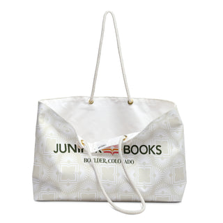 One handle of Juniper Books Book Club Bag rests down to display inside of bag. Inner bag is white canvas.