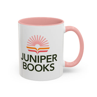 Juniper Books Logo Mug in pink. Outside of mug is white with Black Juniper Books logo. Interior and handle are light pink.