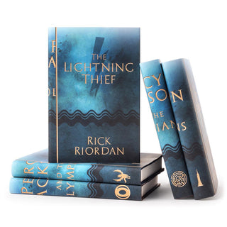 Blue watercolor style book covers featuring gold symbols on each spine and Percy Jackson and the Olympians typed across spine in gold serif font. Cover of each book feature book title and author name set against a large silhoutte of each symbol against a blue background.