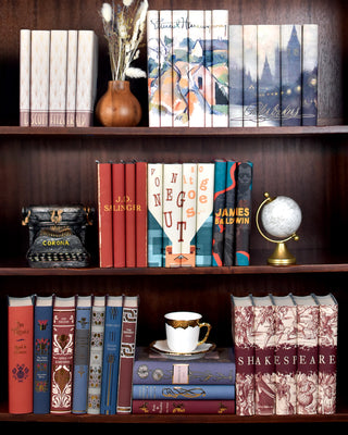 Classic Book sets from Juniper Books sitting on a dark wooden shelf. Book sets include Ernest Hemingway, Shakespeare, F. Scott Fitzgerald, and Charles Dickens.