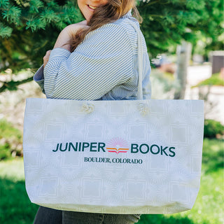 Model holding neutral bag on their shoulder against a nature backdrop