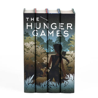 A girl with a bow and arrow standing in front of dense foliage. The Hunger Games custom book set with collectible dust jackets from Juniper Books.