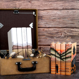 Special Edition book covers for John Steinbeck book set styled against a wood background with covers by Juniper Books.