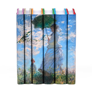 Book set featuring the works of the Brontë sisters with dust jackets displaying Claude Monet's iconic painting 'Woman with a Parasol.' The design spans across the spines of six books, creating a seamless image of the artwork, showcasing a vibrant blue sky, white clouds, and a figure holding a green umbrella with the Brontë signature set against the sky behind the woman.