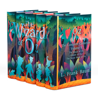 A five-book hardcover collection of 'The Wizard of Oz' series, displayed at an angle to showcase the front and spine designs. The spines feature silhouettes of Toto, the Cowardly Lion, the Tin Man, Dorothy, and the Scarecrow walking along a yellow brick road through a stylized, colorful forest. The cover of the fifth book reads, 'The Complete Collection Volume 5' and lists the story titles.The artwork is vibrant, with shades of teal, orange, and purple, and the author’s name, L. Frank Baum.