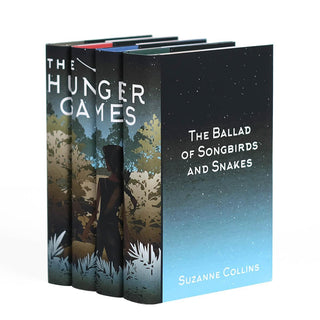 A girl with a bow and arrow standing in front of dense foliage. The Hunger Games custom collectible dust jackets from Juniper Books.