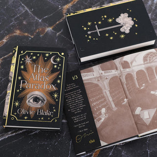 Open book in the Atlas Series displaying flap text and digital signature from Author Olivie Blake on inner front flap. Book surrounded by front and back cover of other books in the trilogy set against a black marble background.