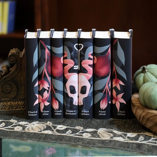 Hades x Persephone Saga book set by Juniper Books styled on a coffee table, black and pink dust jackets anchoring the display.